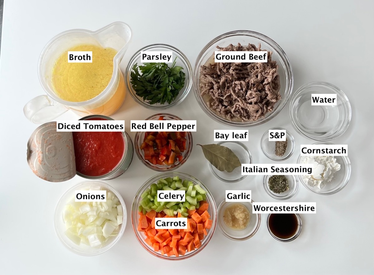 All labeled ingredients prepped and measured out into bowls on white counter for Ground Beef Vegetable Soup Recipe. It's a perfect fall meal that's comforting, hearty, and delicious with loads of veggies!