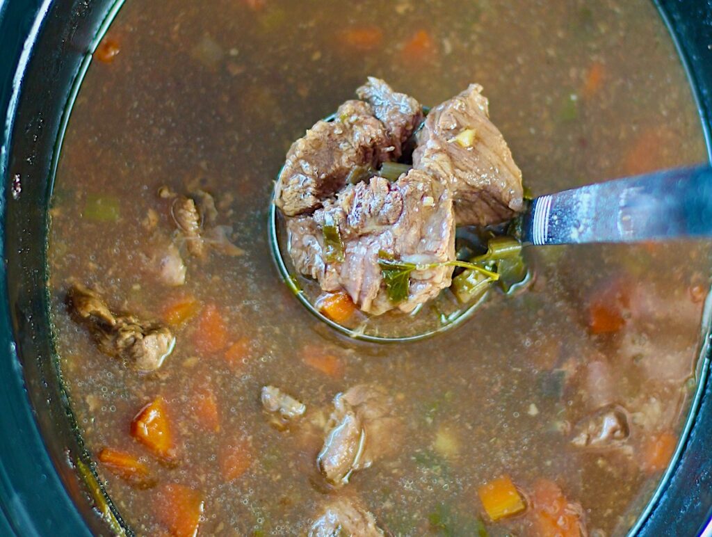 Ladle scooping Korean Beef Stew from a crockpot. Korean Beef Stew is sweet, salty, tangy, and oh-so flavorful!