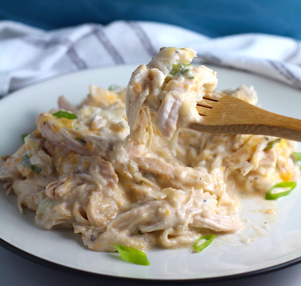 Chicken Hashbrown Casserole Recipe on a plate with a fork scooping a bite up.