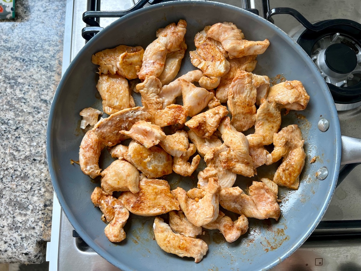 Seasoned chicken pieces cooking in a skillet for Salsa Chicken Casserole Recipe.