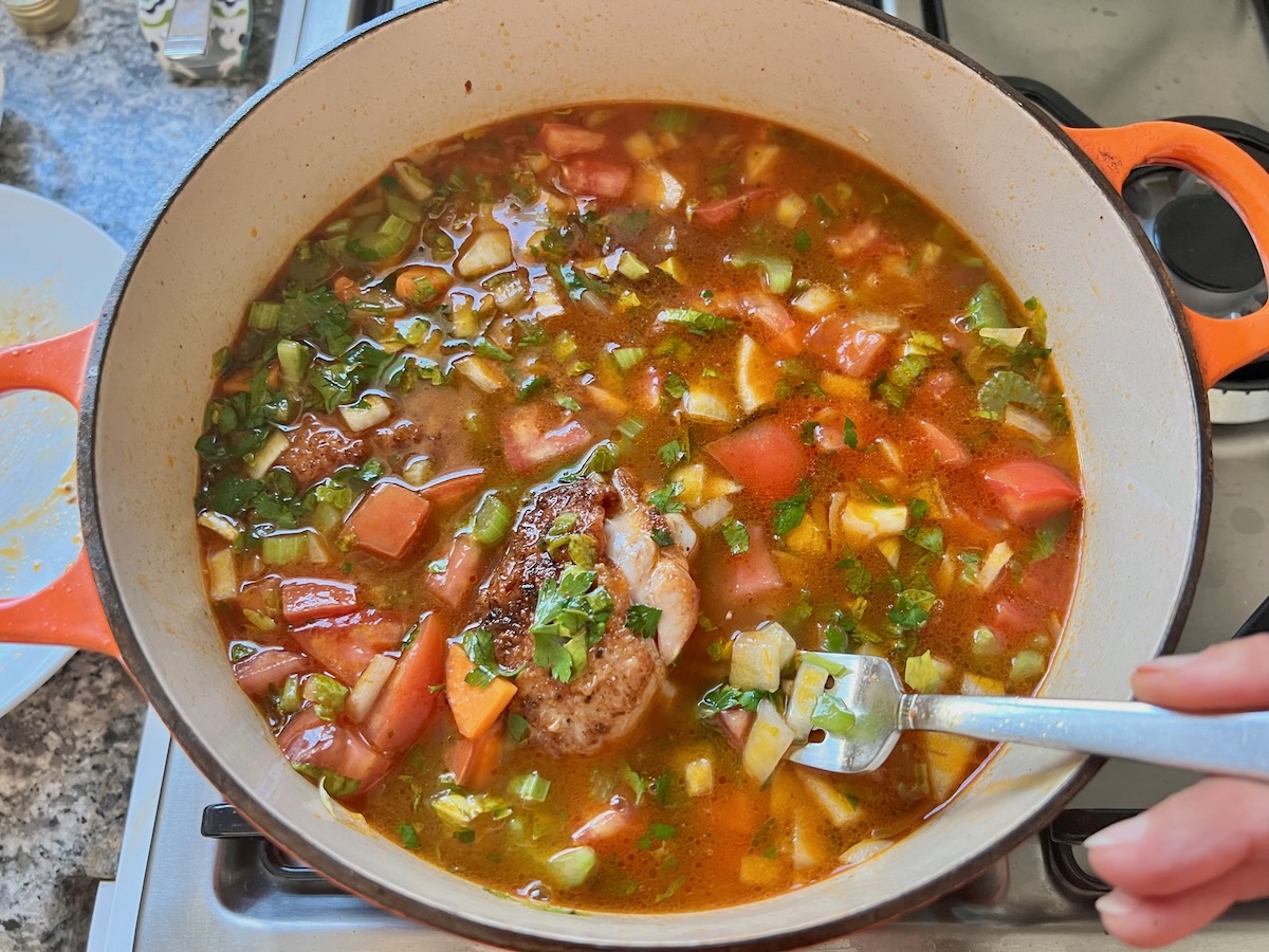 Stock and chicken added to pot with the other ingredients for Spanish Chicken Soup recipe.