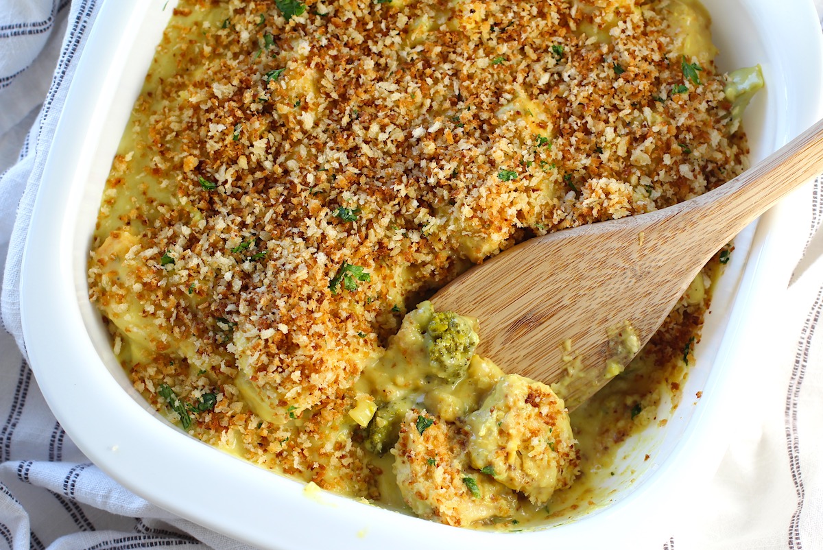 Wooden Spatula scooping the corner of Creamy Broccoli Chicken Curry Casserole Recipe from the casserole dish.