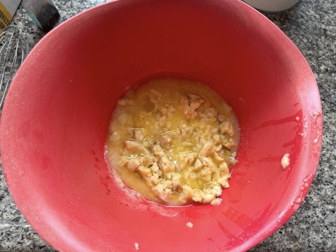 Melted butter and mashed banana in a mixing bowl for oat banana chocolate chip muffins.