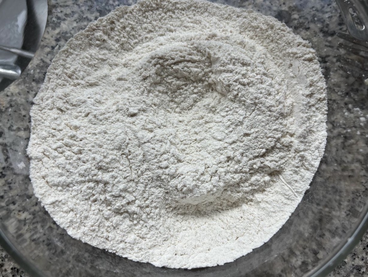 Dry ingredients to prepare oat banana chocolate chip muffins in a mixing bowl.