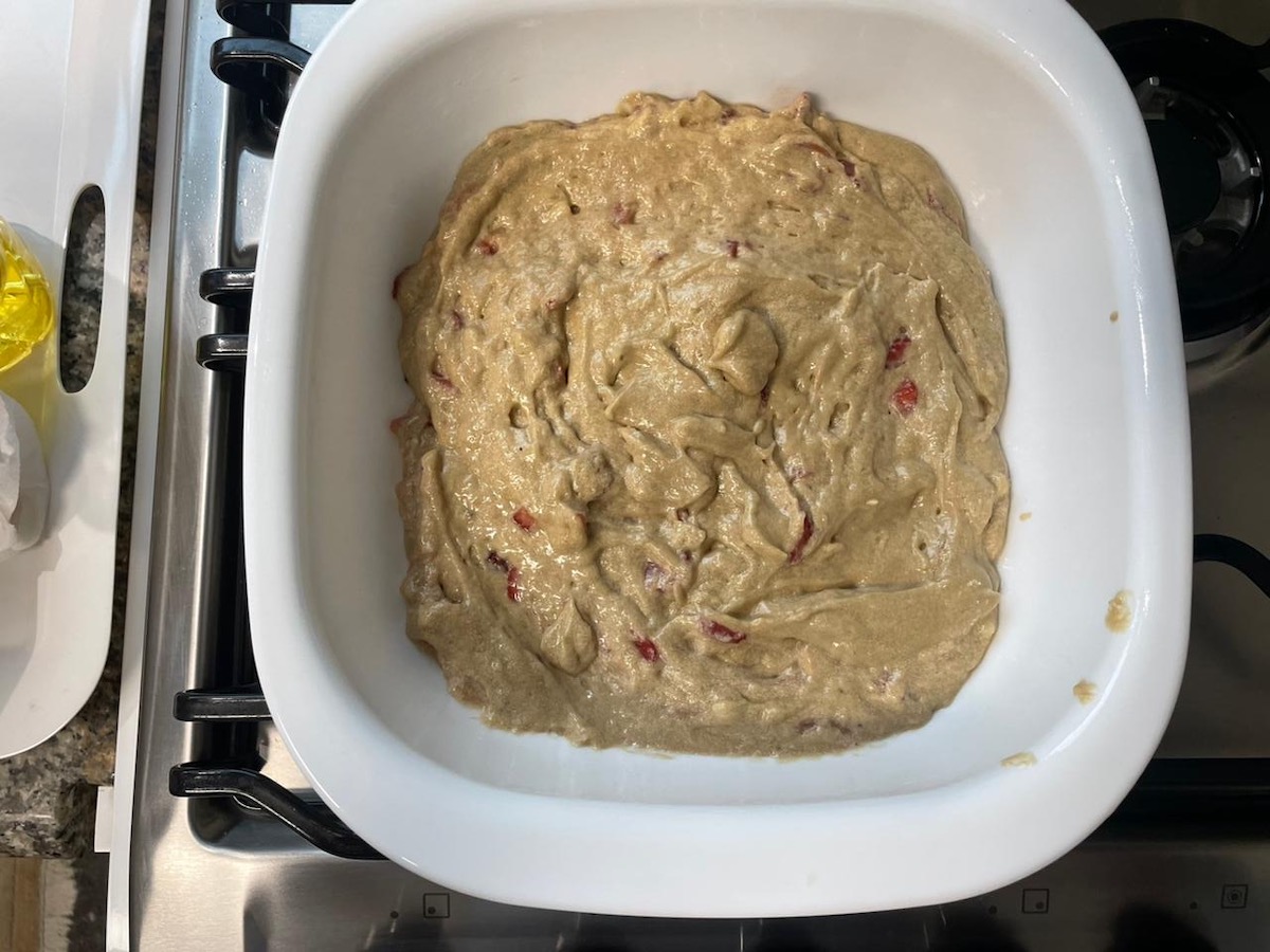 Strawberry Banana Cake batter poured into a 9x9 square baking dish before going into the oven to bake.