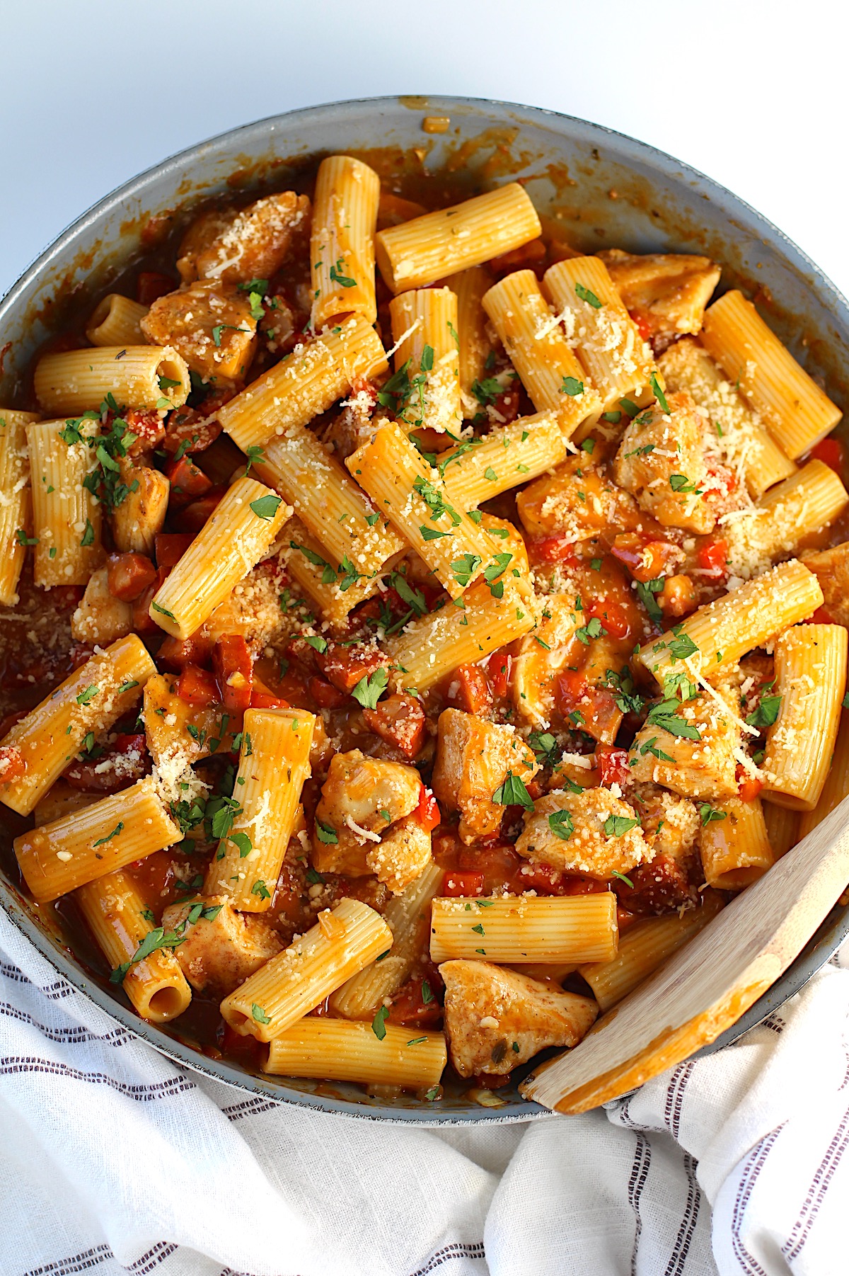 Pasta with chorizo and seasoned chicken in a robust creamy sauce garnished with parsley and ready to serve.