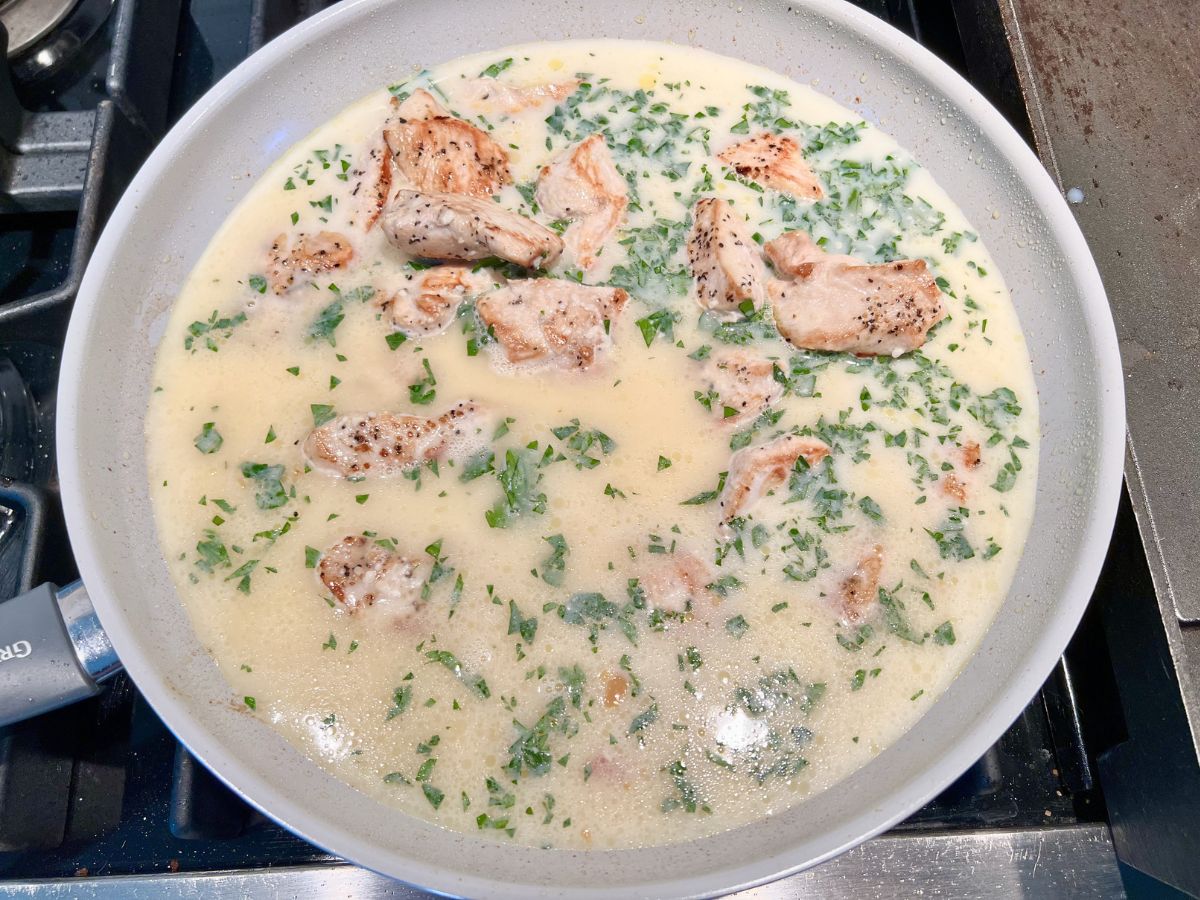 Slurry added to the cooked chicken chunks in the skillet.