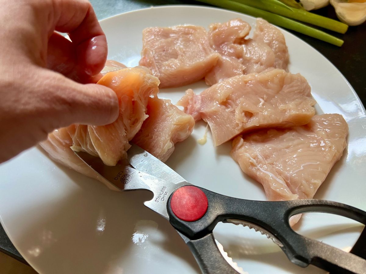 Scissors used to cut up chicken breast into chunks.