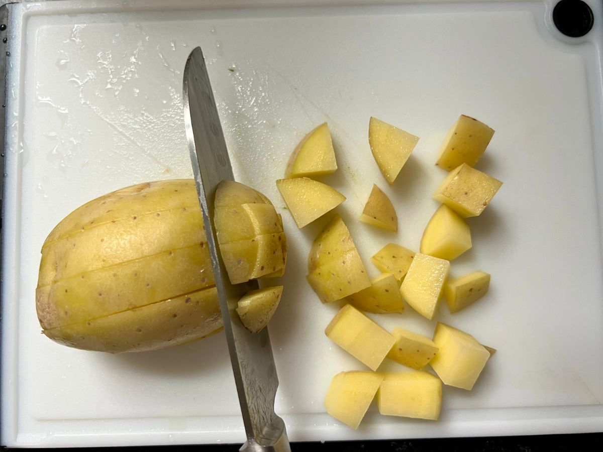 Potatoes being diced on a cutting board.