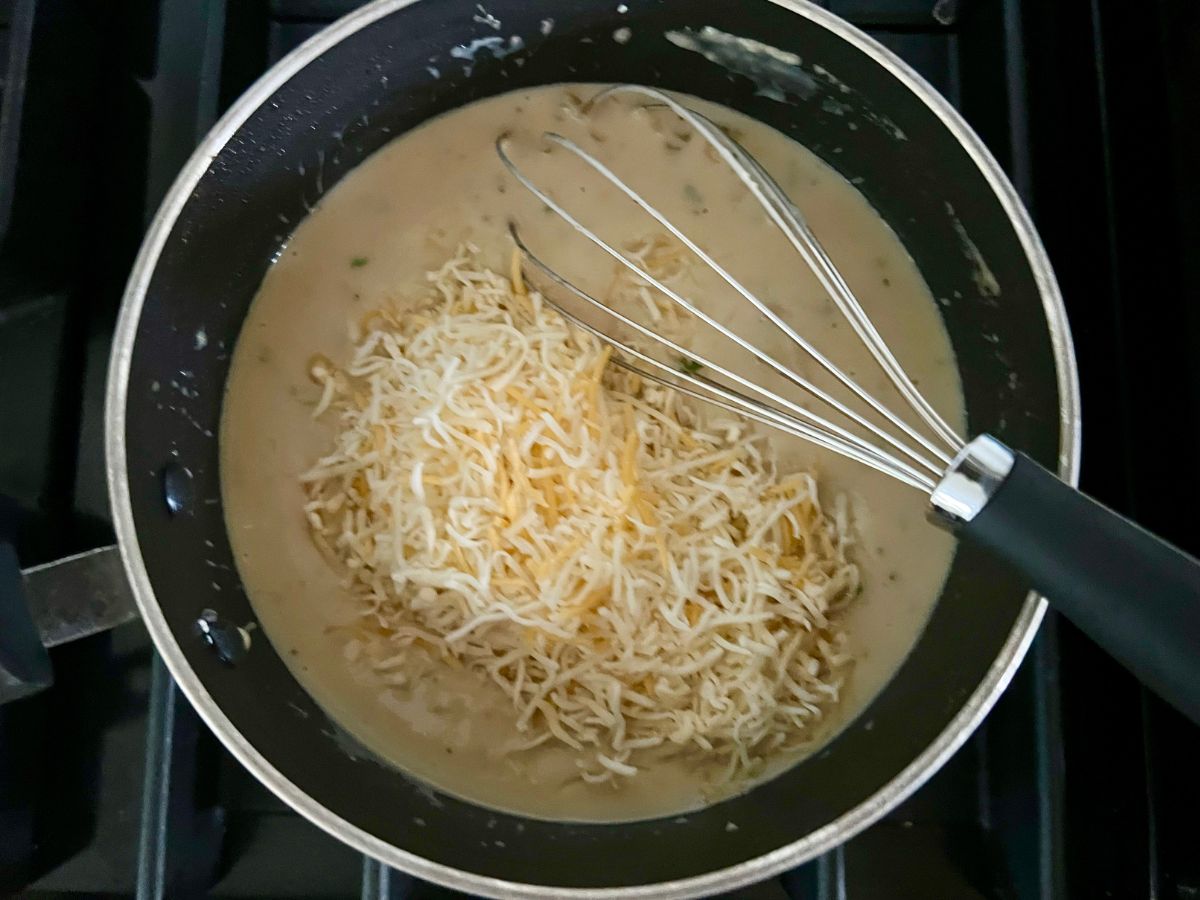 Whisk folding in the cheese to the sauce mixture.