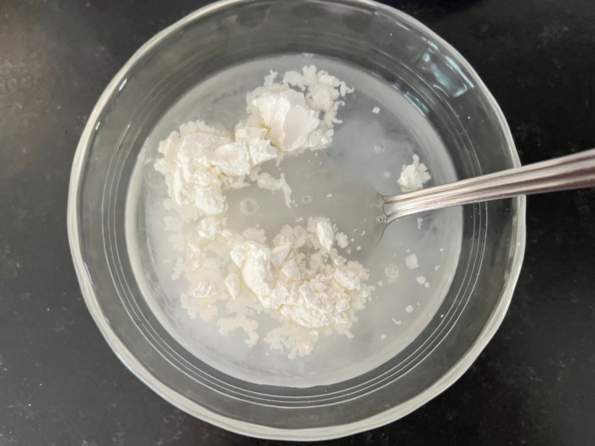 Cornstarch slurry being combined in a small bowl.