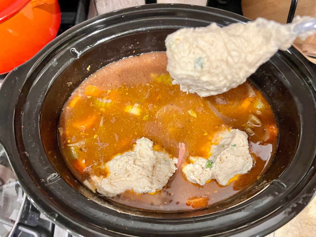 Scoops of dumpling batter added to the beef stew in the slow cooker.