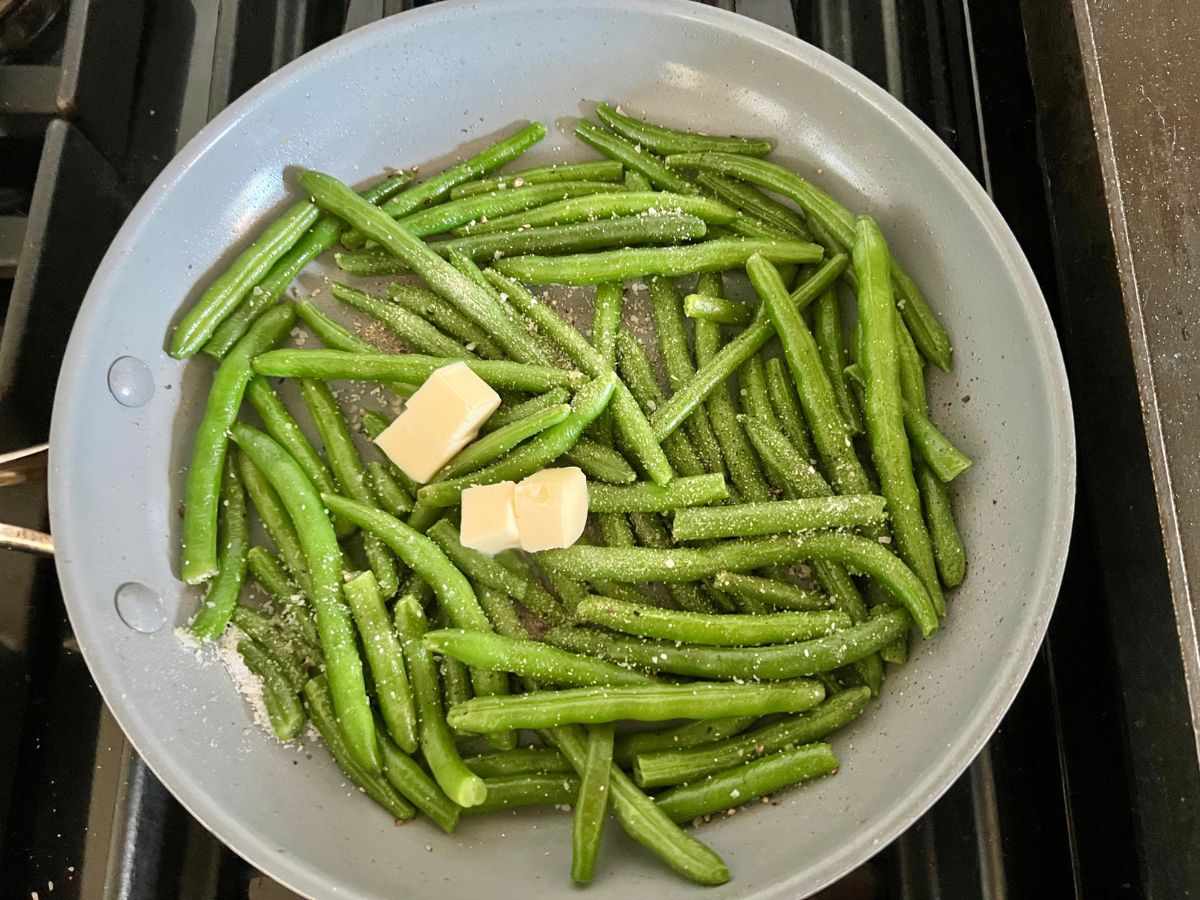 Butter and seasoning added to the skillet green beans.