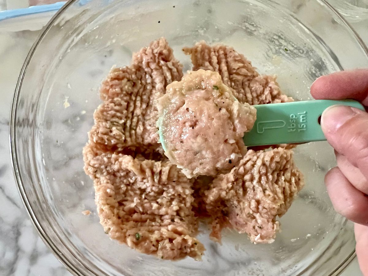 Tablespoon filled with ground chicken mixture.