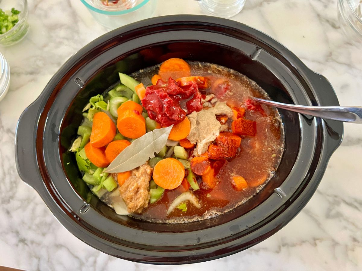 Broth, veggies, seasonings added to the beef stew meat in the slow cooker.
