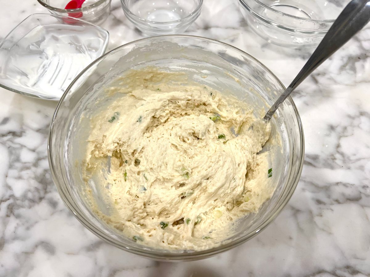 Dumpling mixture combined in a mixing bowl with a fork resting in it.