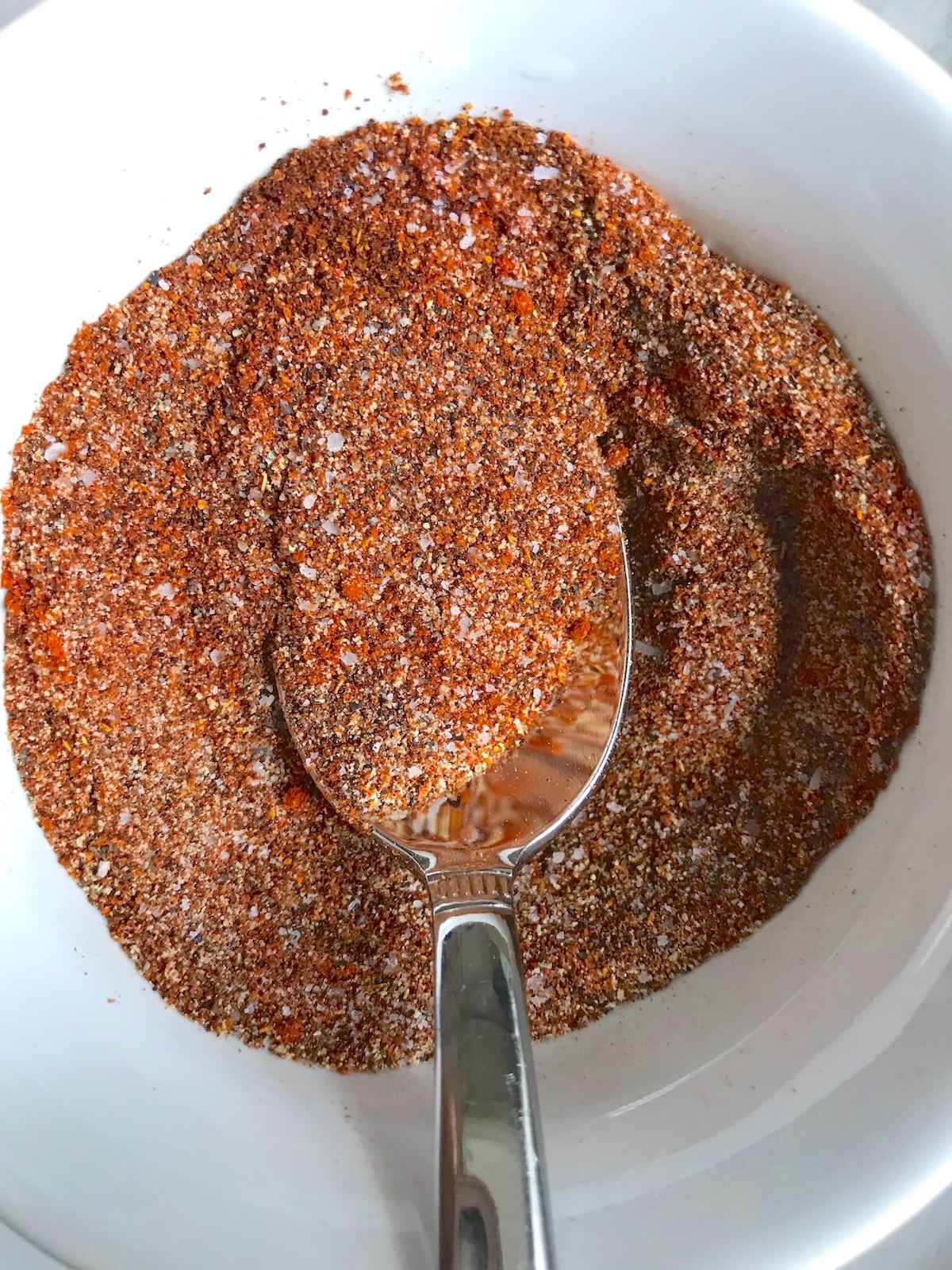 Taco Seasoning for Chicken Recipe -seasonings mixed in bowl (clockwise) smoked paprika, cumin, chili powder, garlic powder, and salt.