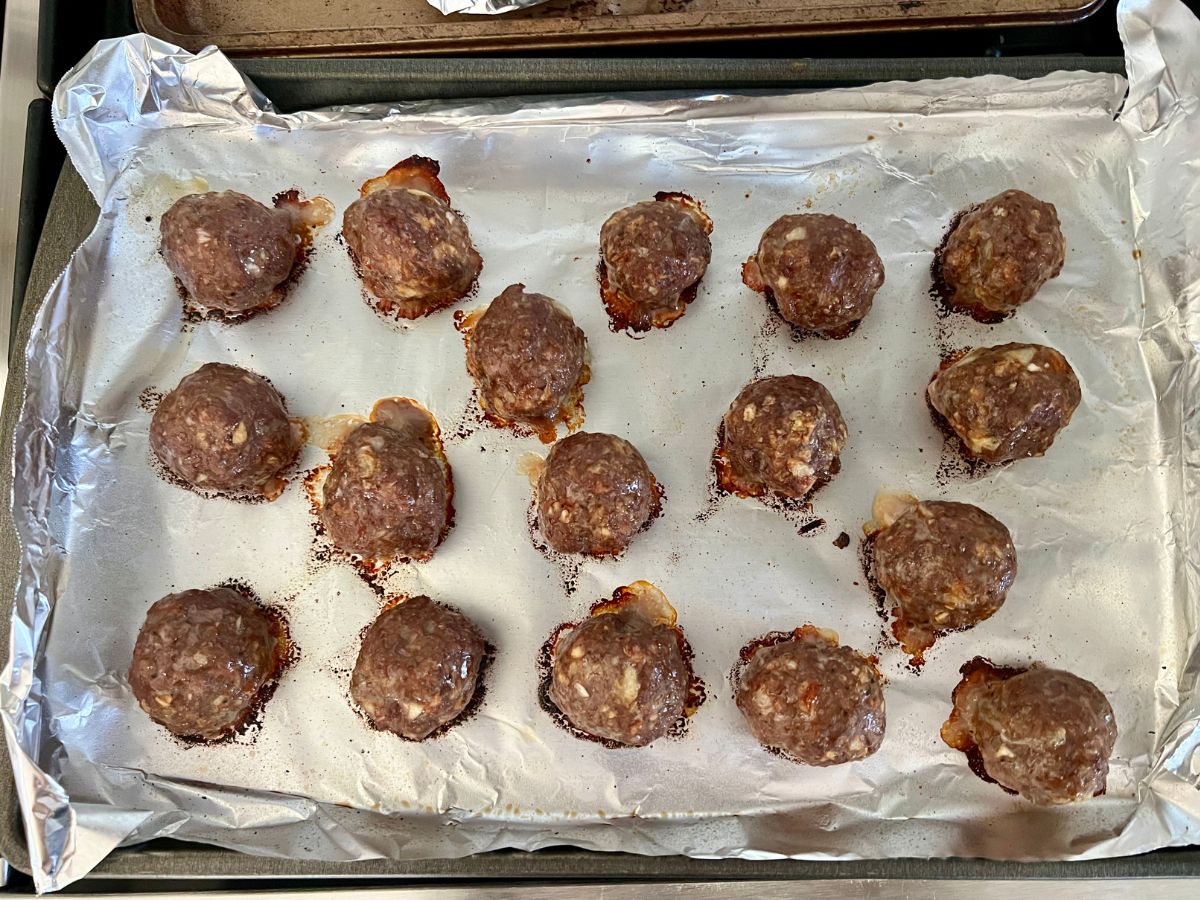 Baked meatballs on a baking sheet.