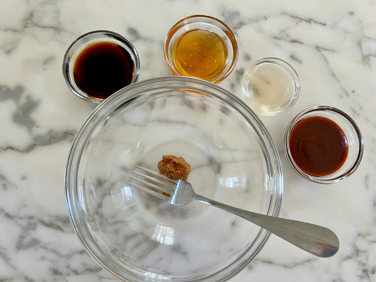 Honey chili sauce ingredients portioned in small bowls ready to pour in one large bowl and combined .