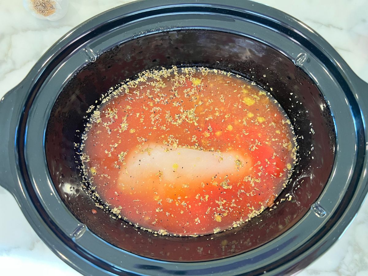 Add stock, seasonings and tomato sauce with chicken breasts to slow cooker.