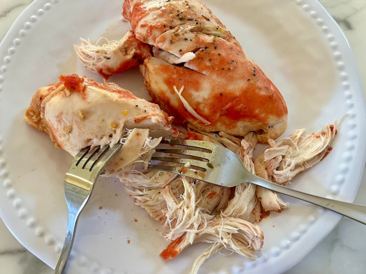 Remove cooked chicken breasts to a plate and shred using two forks.