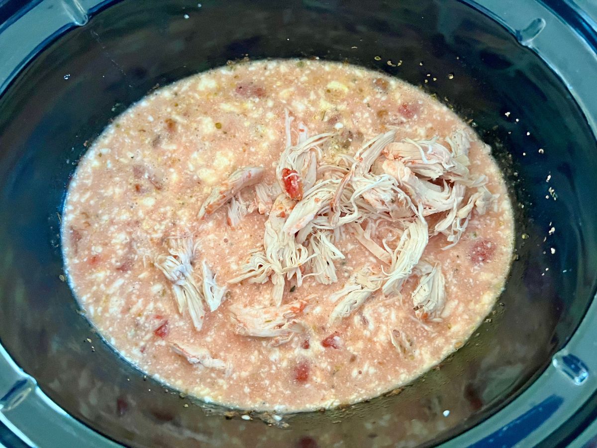 Shredded chicken added back to creamy tomato mixture in slow cooker.