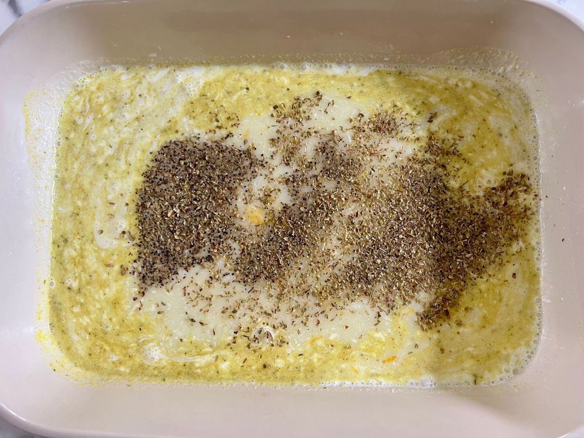 Seasonings added to the baking pan with the broth mixture.