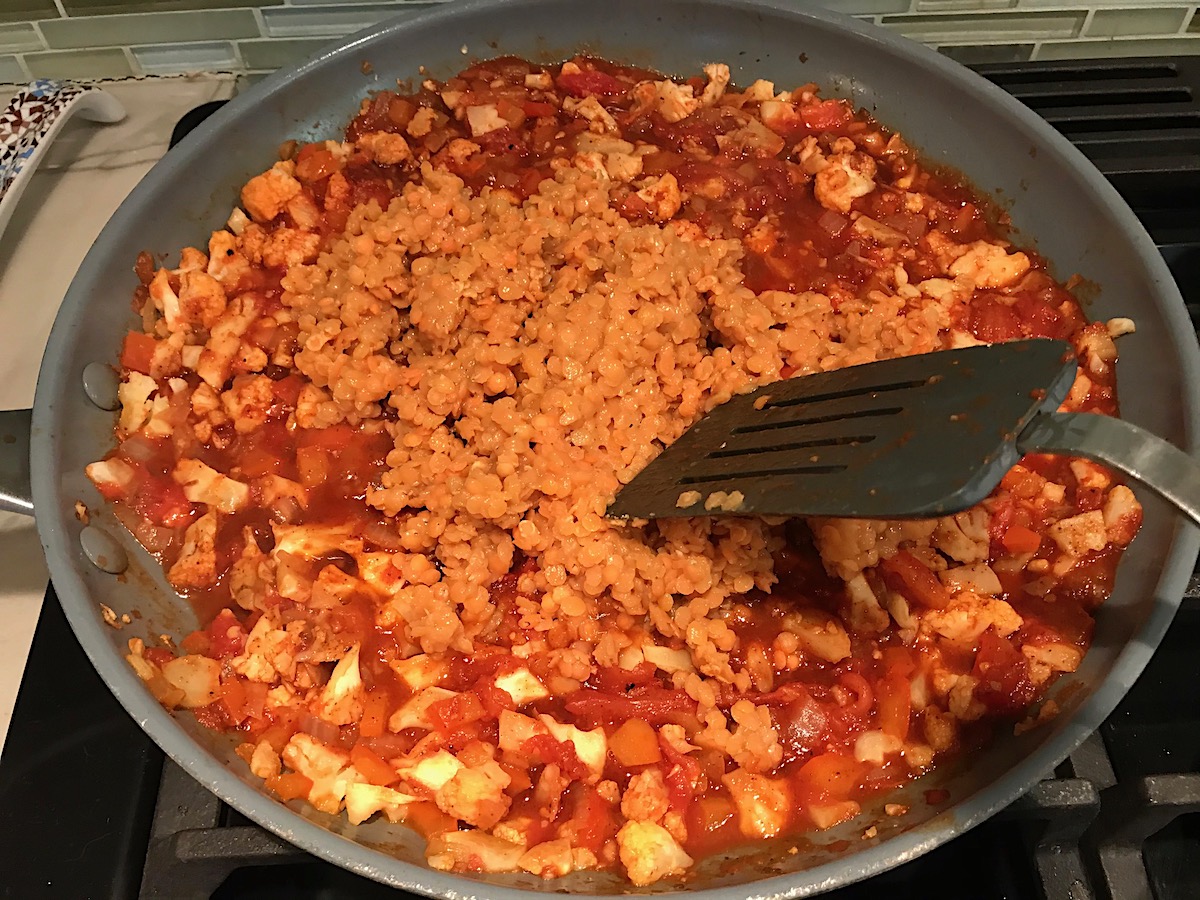 Lentils added to pan cooking sauce, cauliflower, red pepper, onions, and minced garlic for the Vegetarian Sloppy Joes recipe.