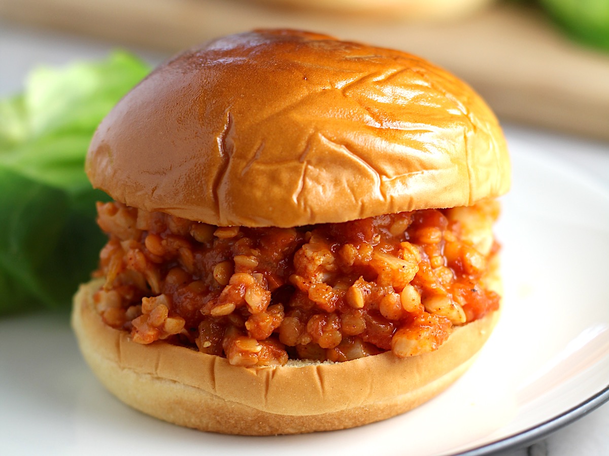 Vegetarian Sloppy Joes sandwich overstuffed with cauliflower and lentils filling in a brioche bun on a plate.