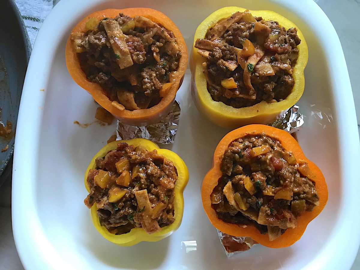 Four Tex Mex Beef Stuffed Peppers without Rice in a white casserole dish before being baked.