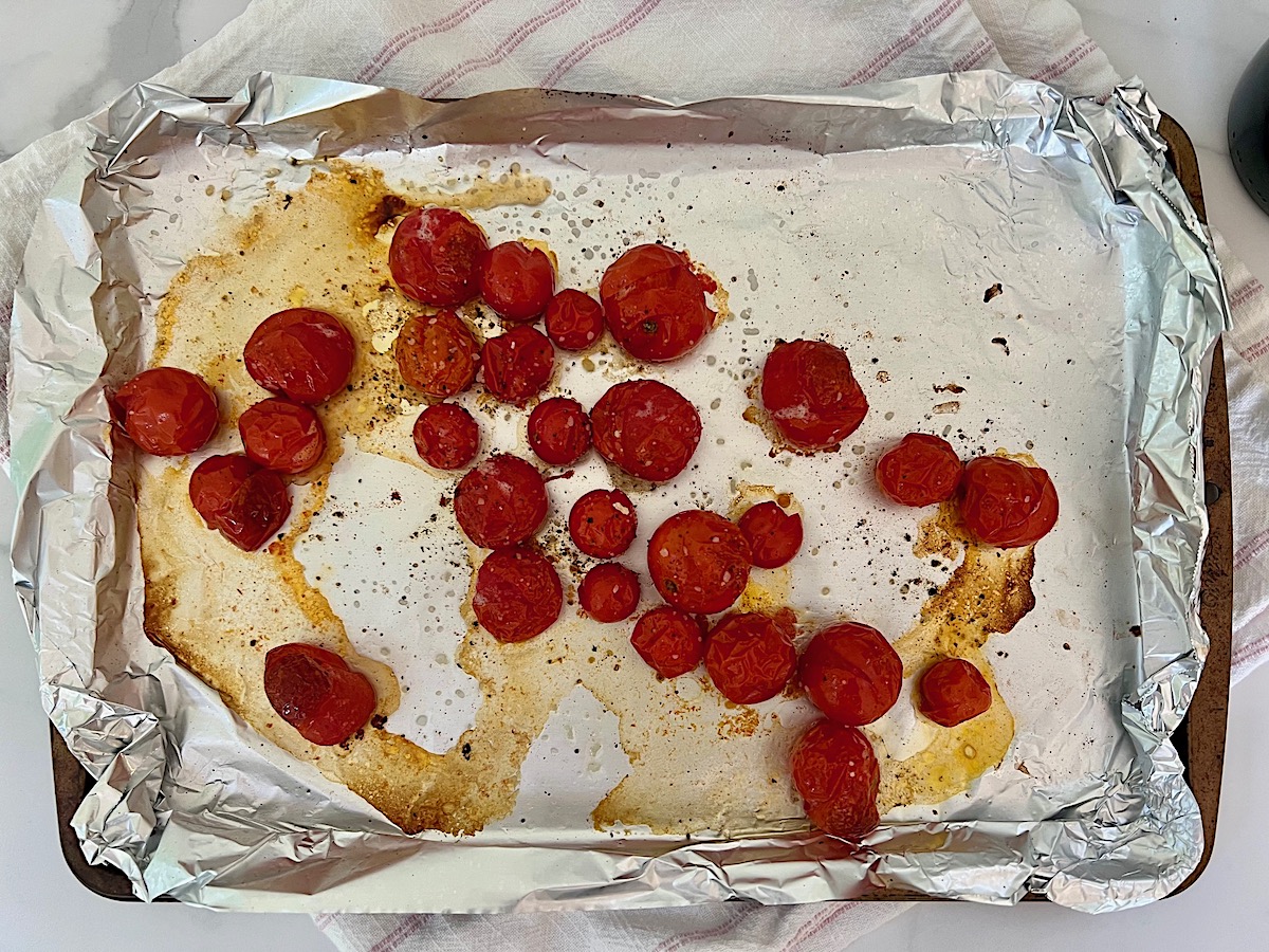 Cherry tomatoes roasted on an aluminum foil lined sheet pan before roasting for Pesto Pasta with Tomatoes.