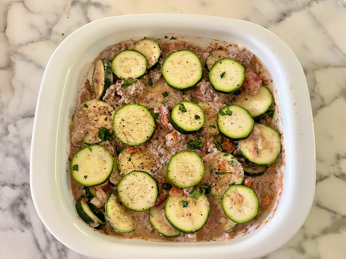 More raw zucchini slices added on top before baking the Ground Beef and Zucchini Casserole recipe.