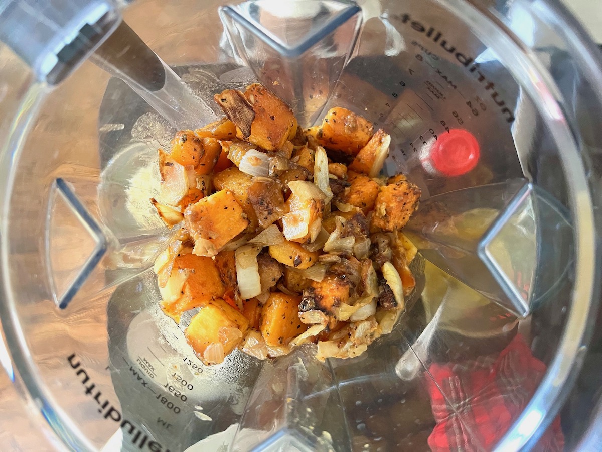 Roasted butternut Squash cubes, diced onions, and seasonings added to a blender before being blended for the Butternut Squash Spaghetti recipe.