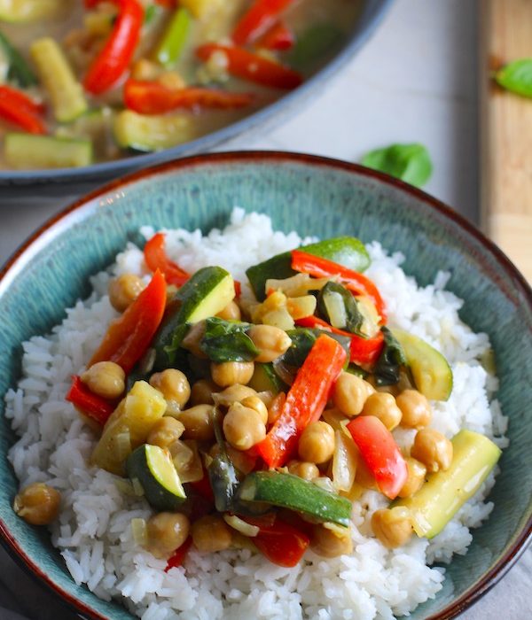 Family Chickpea Coconut Curry over rice in a bowl with red bell pepper, zucchini, onion, coconut milk, and warm Indian Curry spices.