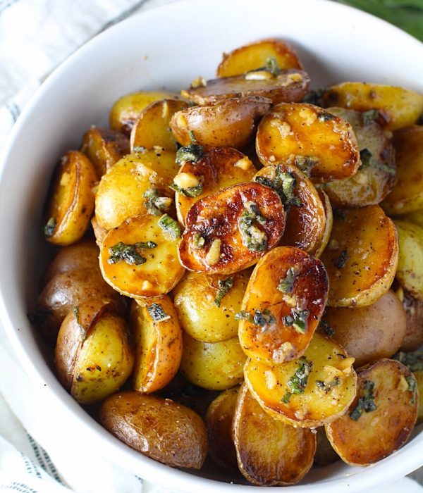 Crispy browned Baby Potatoes with Garlic Butter and Sage in a bowl with garlic, sage butter glistening on top.