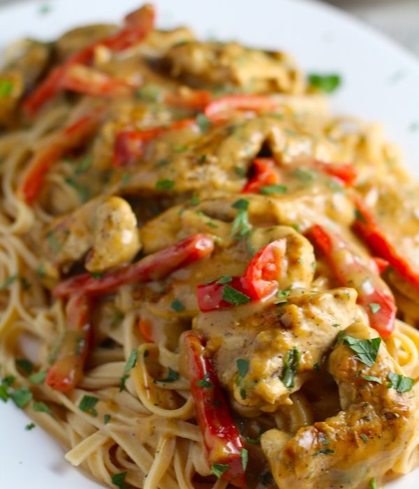 Creamy Tarragon Mustard Sauce with Chicken and Red Peppers over pasta on a plate. It's creamy, tangy, savory, and so addictive.  It gets so much flavor from dijon mustard, tarragon, garlic, and onion. It's an easy-to-whip-up any night dinner! #easydinners